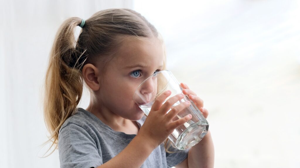 Child drinks water silhouette window background
