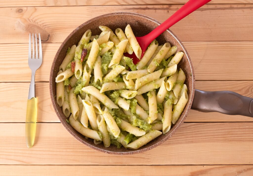 Wooden table with appetizing plate of pasta and broccoli. South italian recipe for a healthy eating